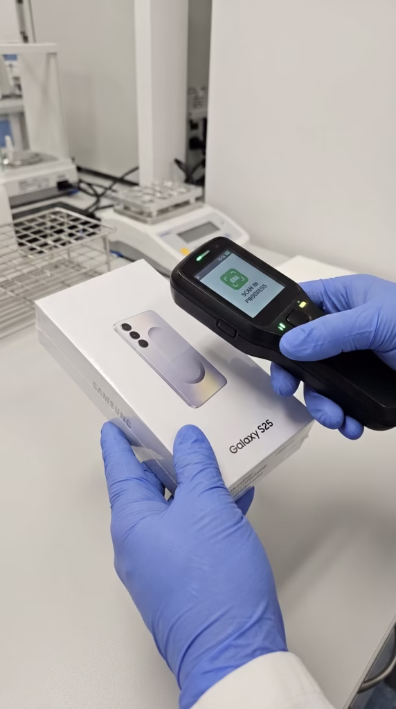 Technician inspecting a sealed, unopened smartphone to verify 100% original factory parts